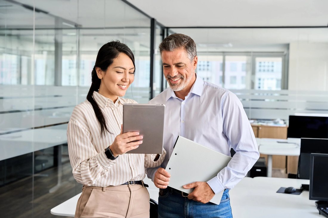 Two colleagues reviewing research on a tablet
